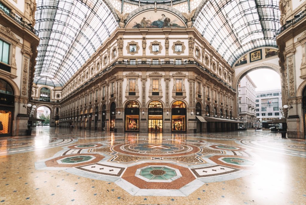 Ornate interior of the Galleria Vittorio Emanuele II in Milan, home to the House of Gucci, with mosaic floors and detailed architecture.