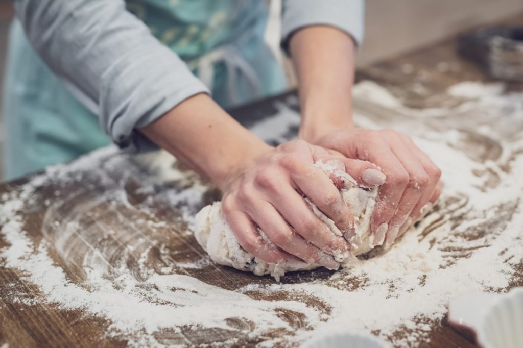 Person kneading shortbread dough on a floured surface.