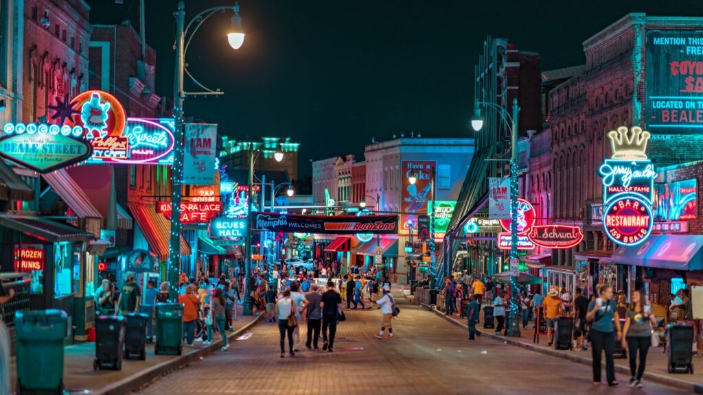 people walking down the neon lit Beale Street Memphis