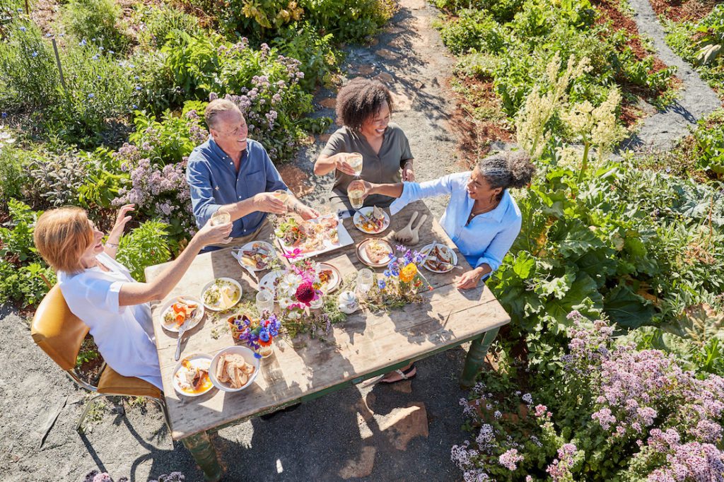 four people enjoying a meal in a garden outdoors food travel memories