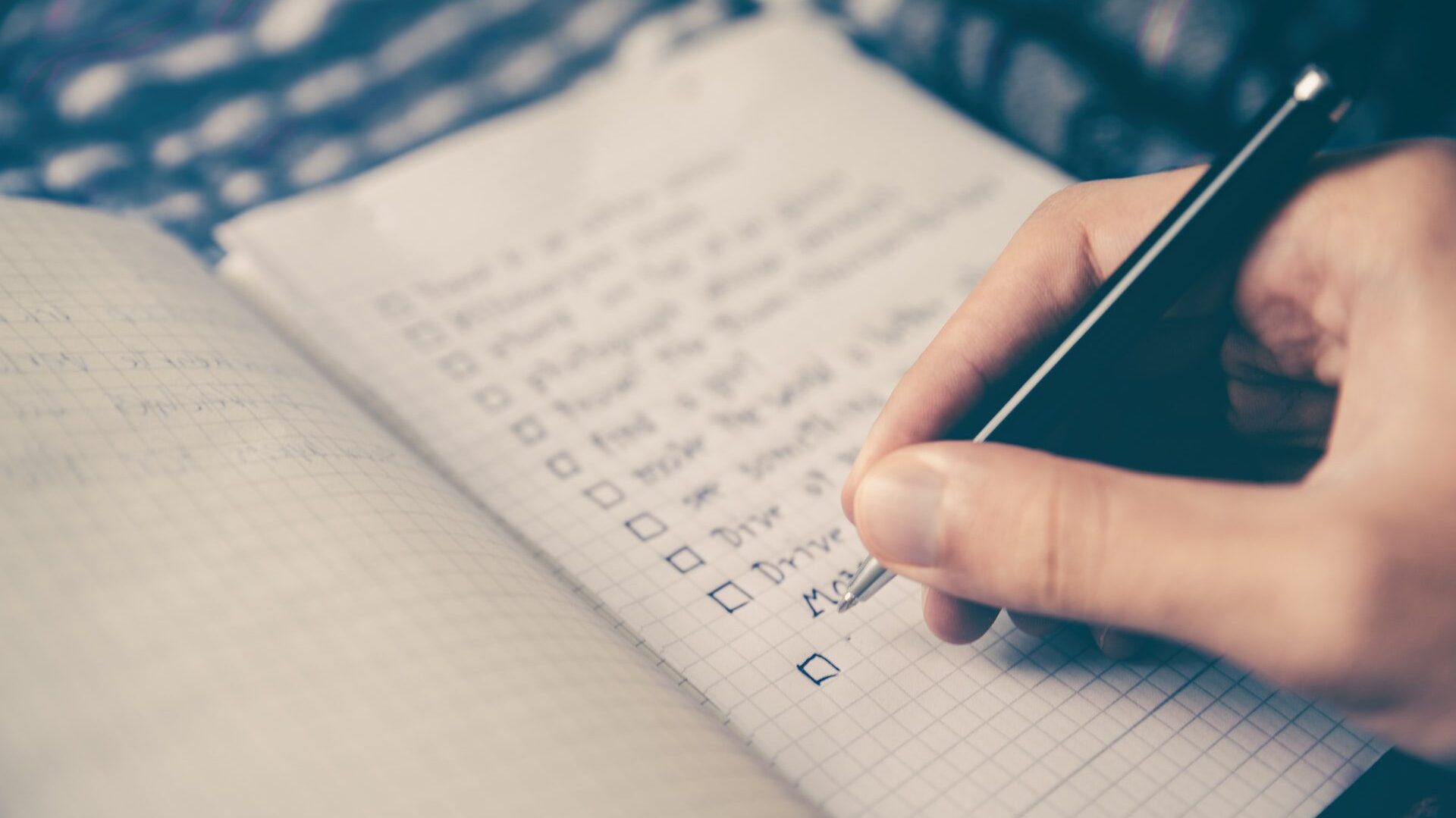 Close-up of handwriting a solo travel checklist in notepad