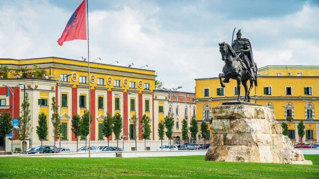The radiant yellow Skanderbed Square, flanked by a statue of the nobleman,  in Tirana, Albania.