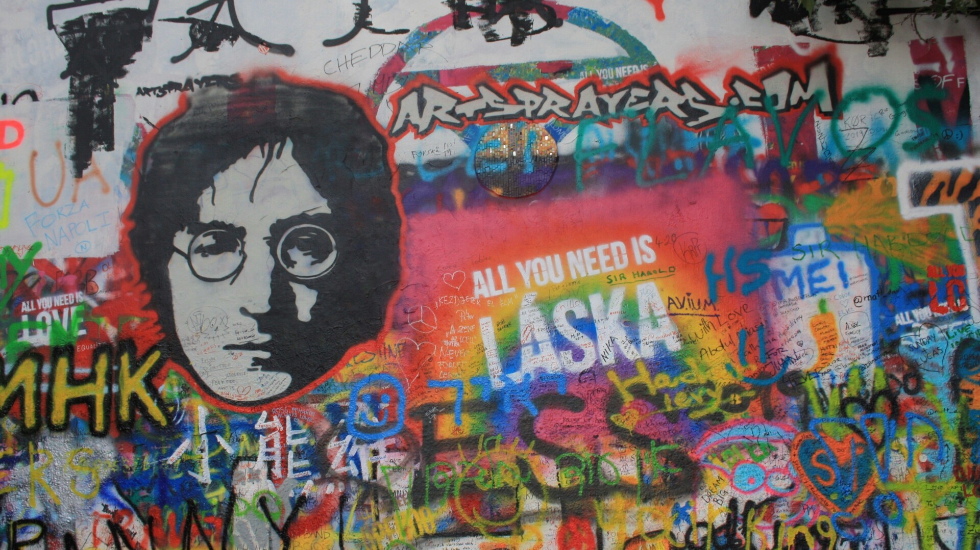Wall of graffiti featuring image of John lennon 