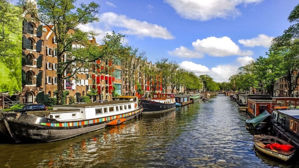 colourful boats and buildings amsterdam canal