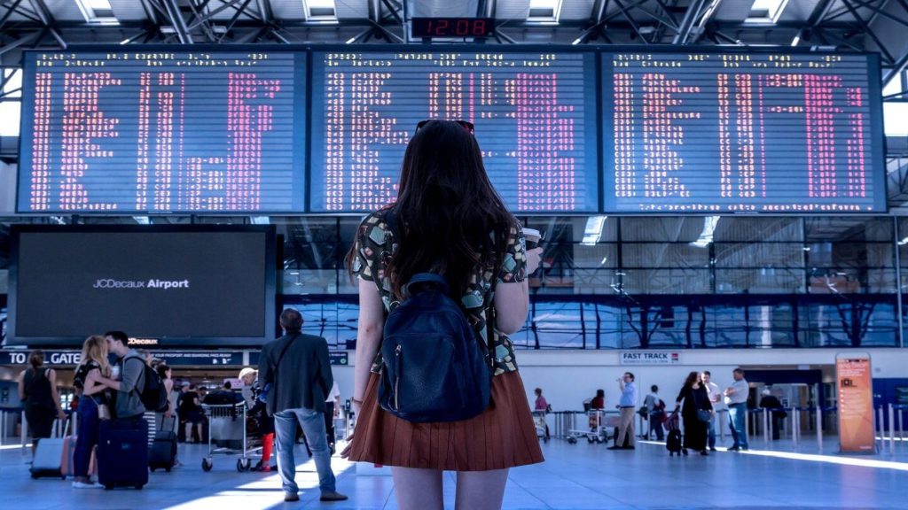 woman waiting at airport frequent flyer tips